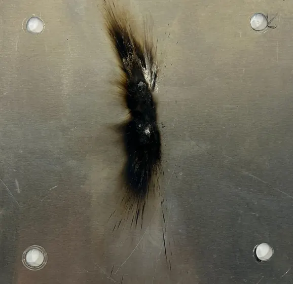 Arc strike scorch mark on a stainless victim plate