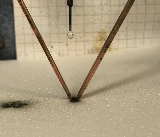 Electrolyte droplet suspended between CTI electrodes on an insulation specimen