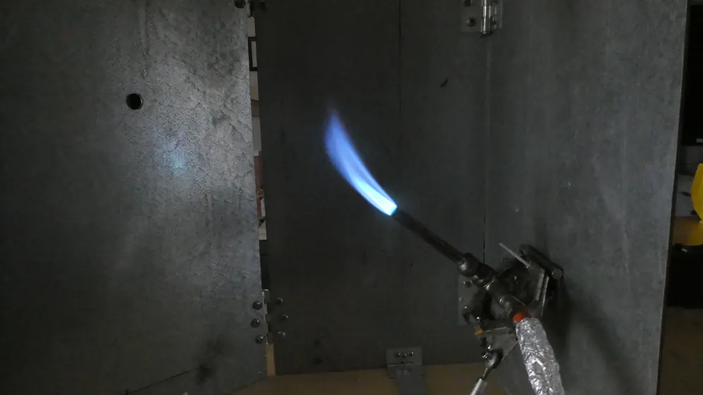 Burner flame applied to a wire specimen in the flammability chamber