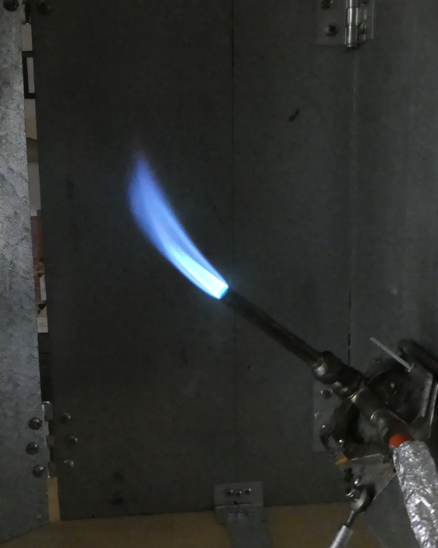 Burner flame applied to a wire specimen in Lectromec's flammability chamber